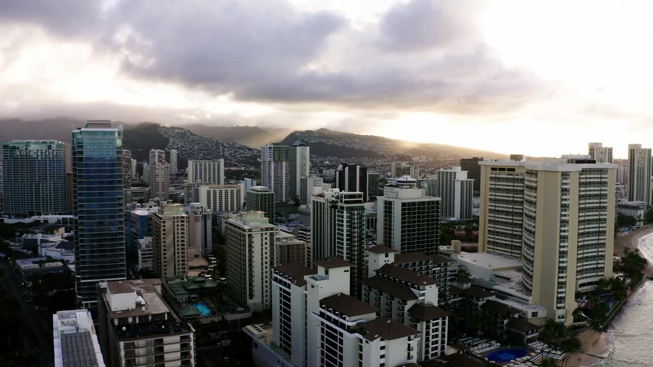 tomada de avión no tripulado de la costa urbana de oahu al atardecer, rascacielos hasta donde llega el ojo