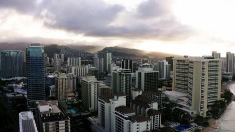 Drone-shot-of-Oahu's-urban-shoreline-at-sunset,-skyscrapers-as-far-as-the-eye-can-see