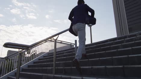 asian man holding smartphone running while climbing up the stairs at corporate park