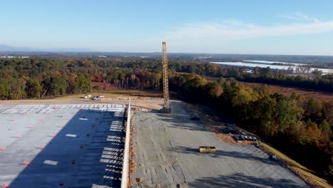 Eine-Drohnenaufnahme-Eines-Schwerlastkrans,-Der-Auf-Einer-Baustelle-An-Eine-Andere-Position-Verlegt-Wird