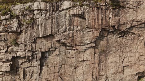 Frau-Klettert-Felswand-In-Norwegen,-Luftaufnahme