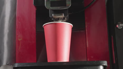 coffee machine dispensing espresso into red paper cup, close-up, brewing coffee in a modern espresso maker. perfect for cafe, coffee shop, or beverage related visuals