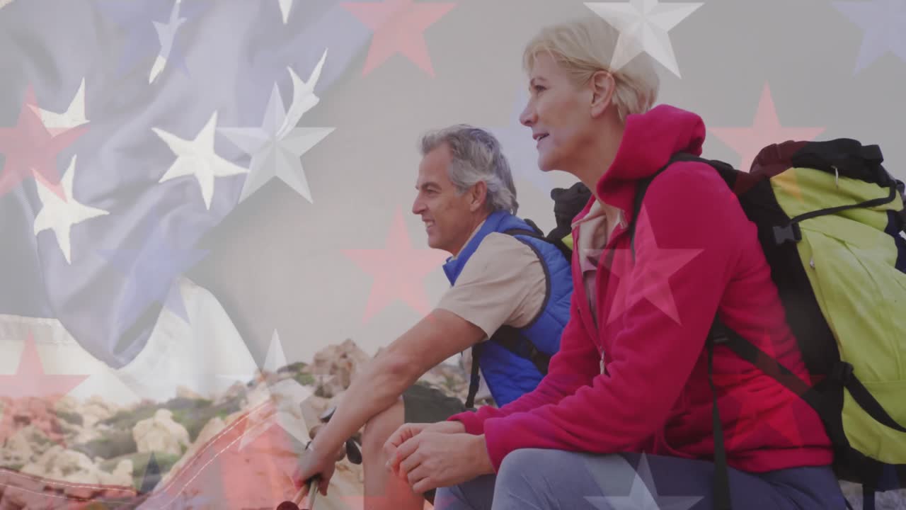 animación de la bandera de los estados unidos de américa sobre una pareja de ancianos haciendo una pausa de senderismo en las montañas