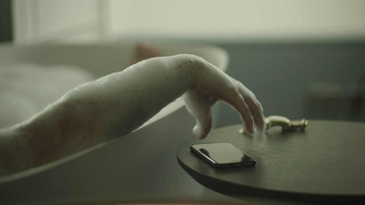 Relaxing in a bubble bath with a phone