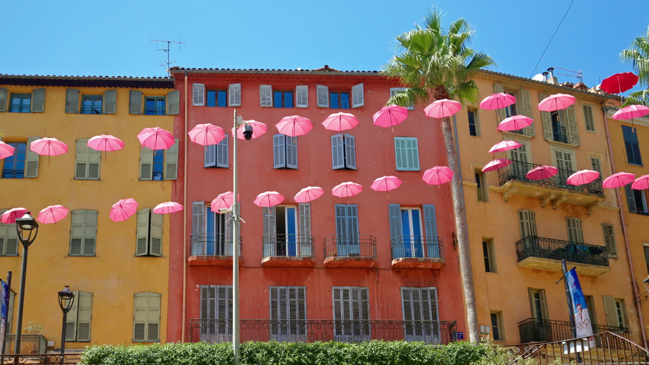 Rows of pink umbrellas above the streets of the old town in Grasse, France
