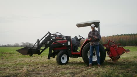 farmer using tablet on tractor in field