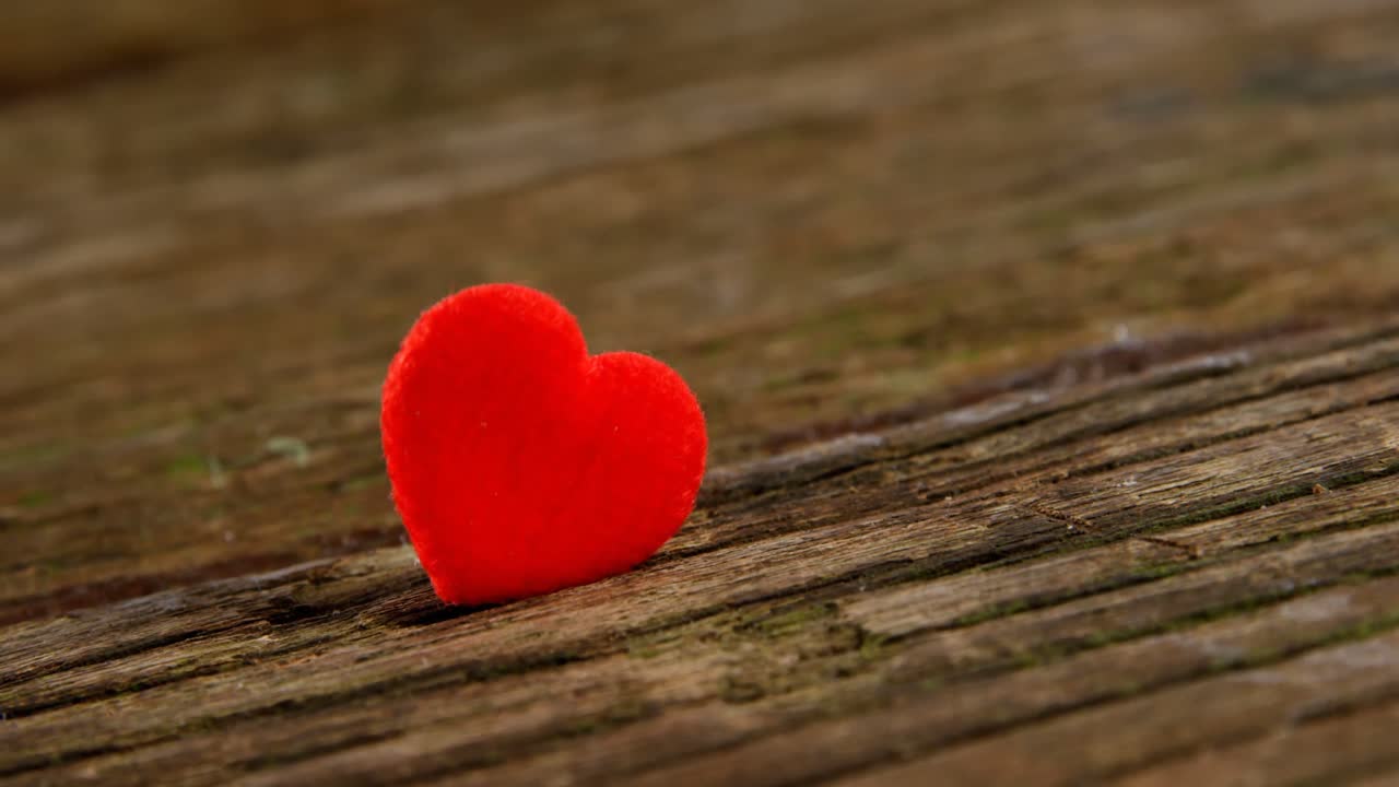 corazón rojo metido en la tabla de madera 4k