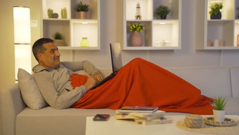 Man-lying-down-chatting-facetime-on-laptop.