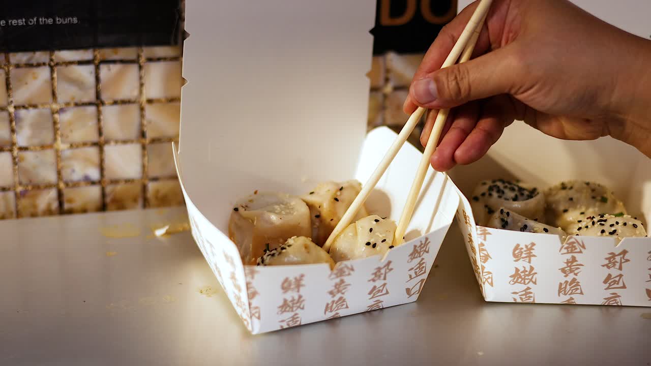 Chopsticks picking up delicious pan-fried buns