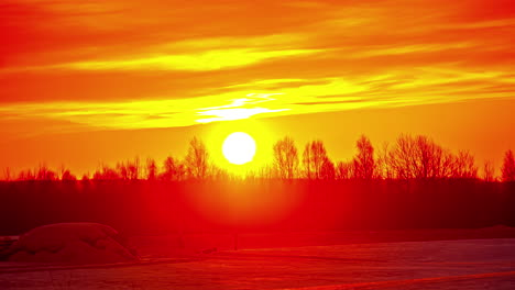 Zeitraffer-Der-Blendend-Gelben-Sonne,-Die-Bei-Sonnenaufgang-Am-Orangefarbenen-Und-Goldenen-Himmel-über-Der-Verschneiten-Landschaft-Aufgeht