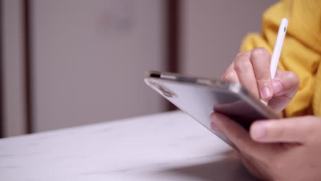 Pan-shot-of-detail-of-female-hands-using-digital-tablet-with-touchscreen-pen