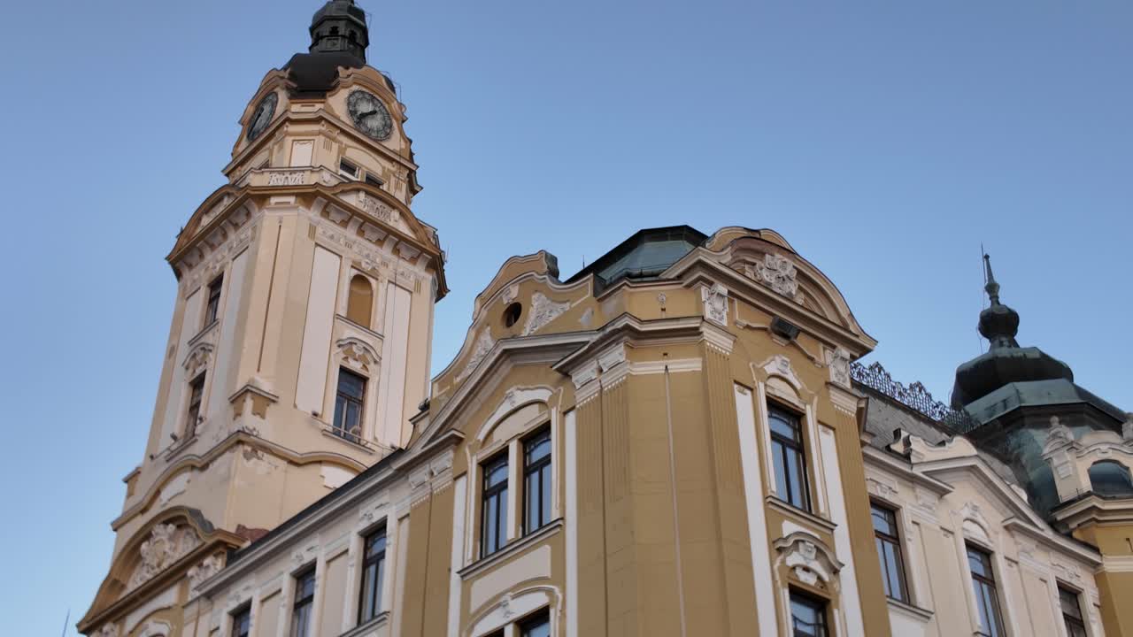 Tilt-up view revealing the majestic tower of Pécs Town Hall, highlighting its historic architecture