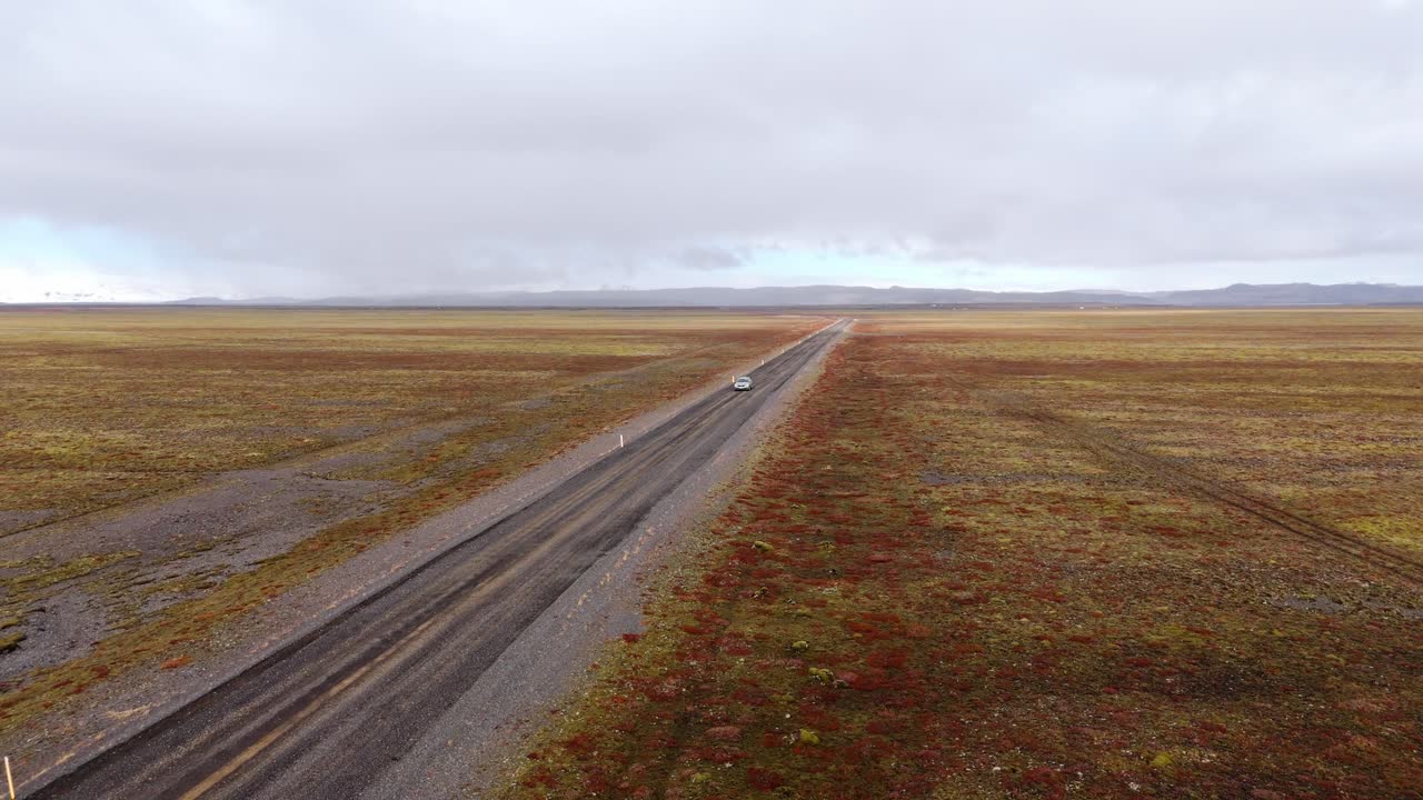 camino vacío que se extiende en la distancia en el vasto paisaje de islandia, cielo nublado