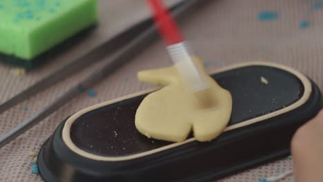 footage of a caucasian woman making and icing whale cookies