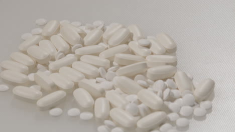 close dolly of various pills on a white surface