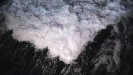 large, churning prop wash wake chasing the stern of a cruise ship under way at night