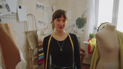 Portrait-of-Positive-Female-Dressmaker-in-Sewing-Workshop