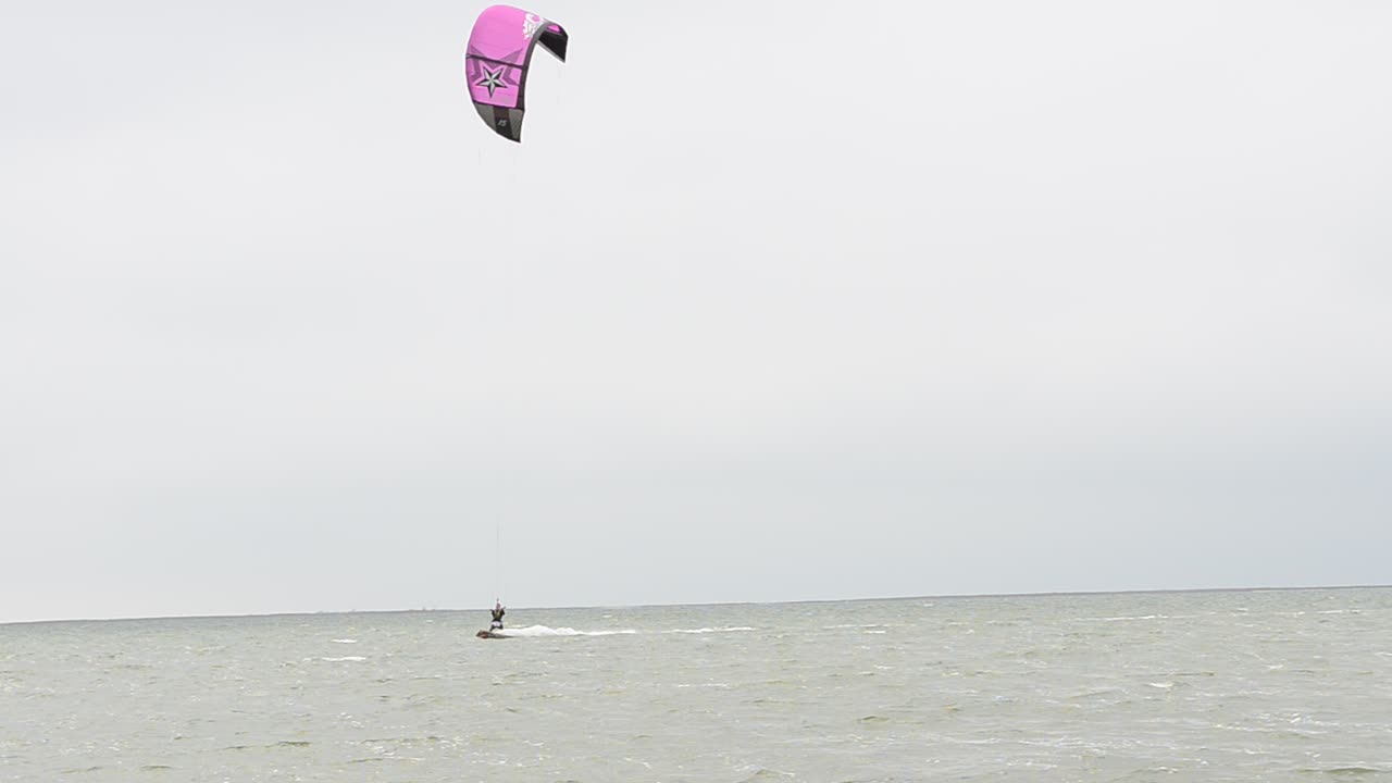 Skysurfing in windy weather. Driving on a board under a sail
