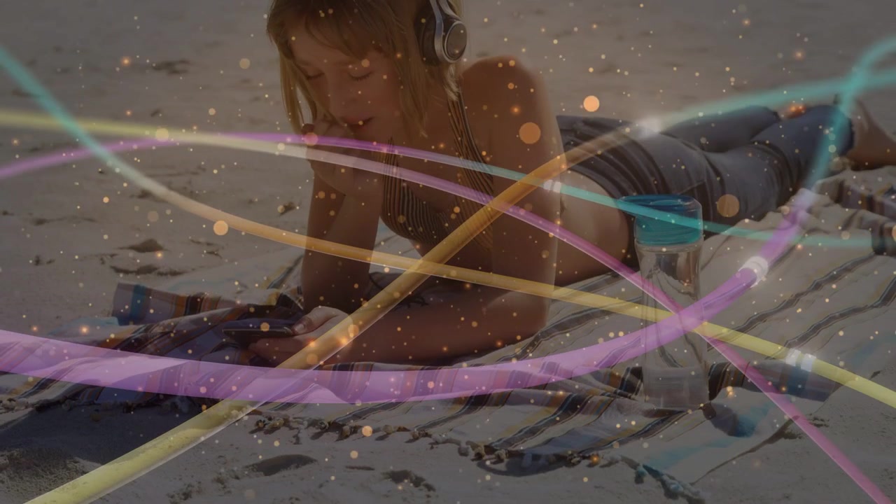 Girl lying on blanket scrolling phone, tapping phone initiating tech ribbons and gold particles