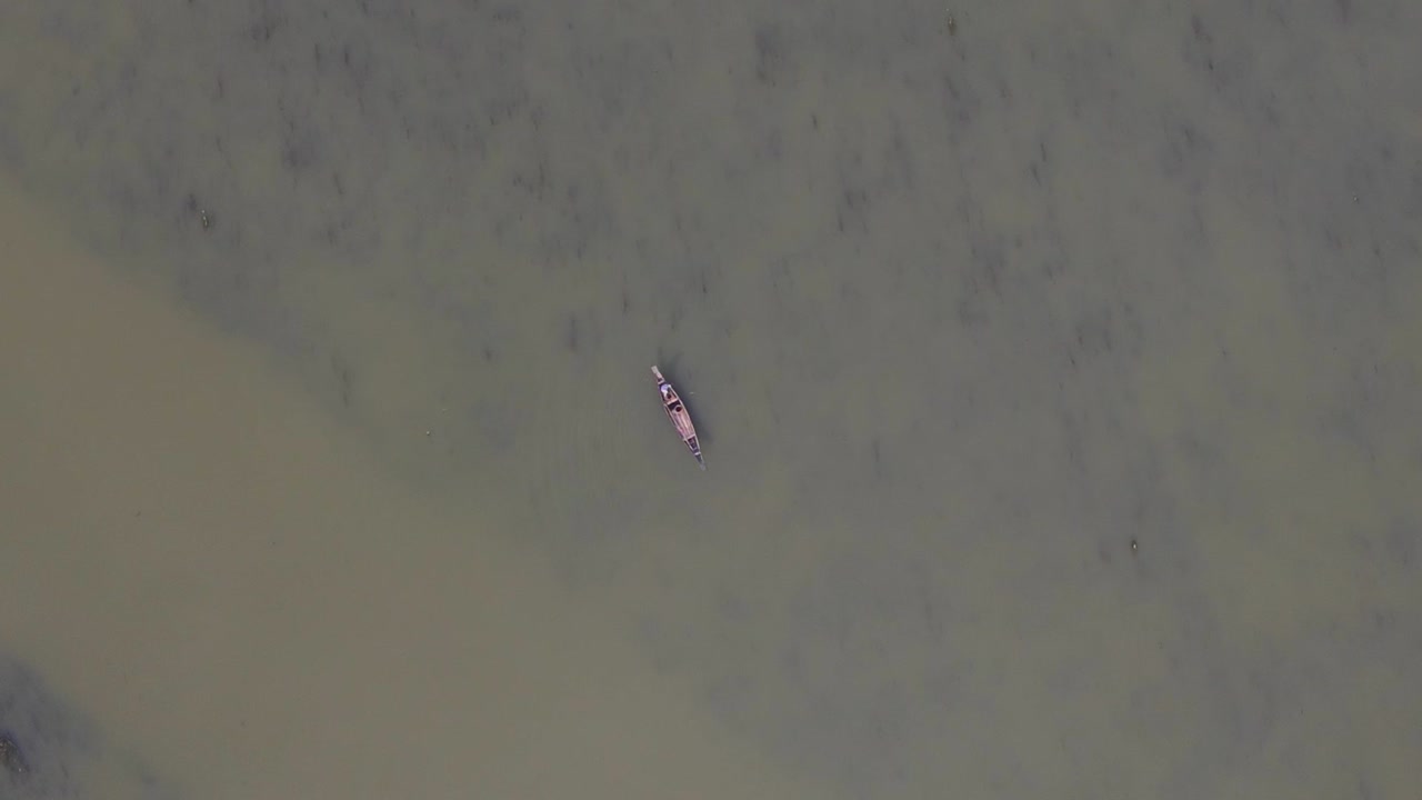 barco de pesca tradicional de madera en interminables aguas sucias del lago, vista aérea de arriba hacia abajo