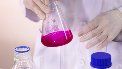 el científico lleva a cabo una reacción química con una solución rosada
