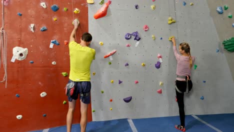 coach assisting woman in bouldering 4k