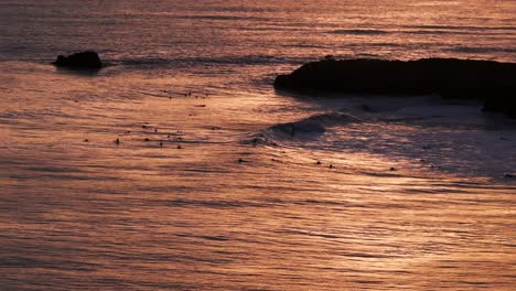 Vista-Aérea-De-Drones-De-La-Puesta-De-Sol-En-Santa-Cruz,-California-Con-Surfistas-Atrapando-Olas