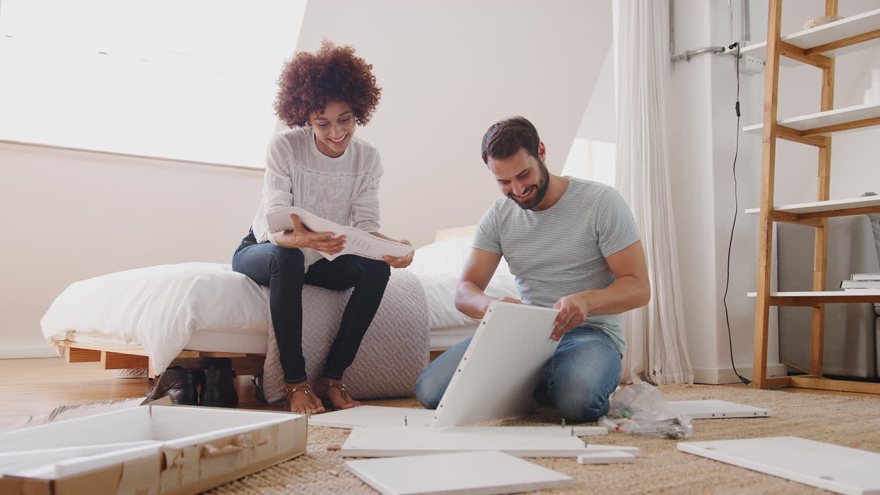 Casal em casa nova montando móveis de automontagem