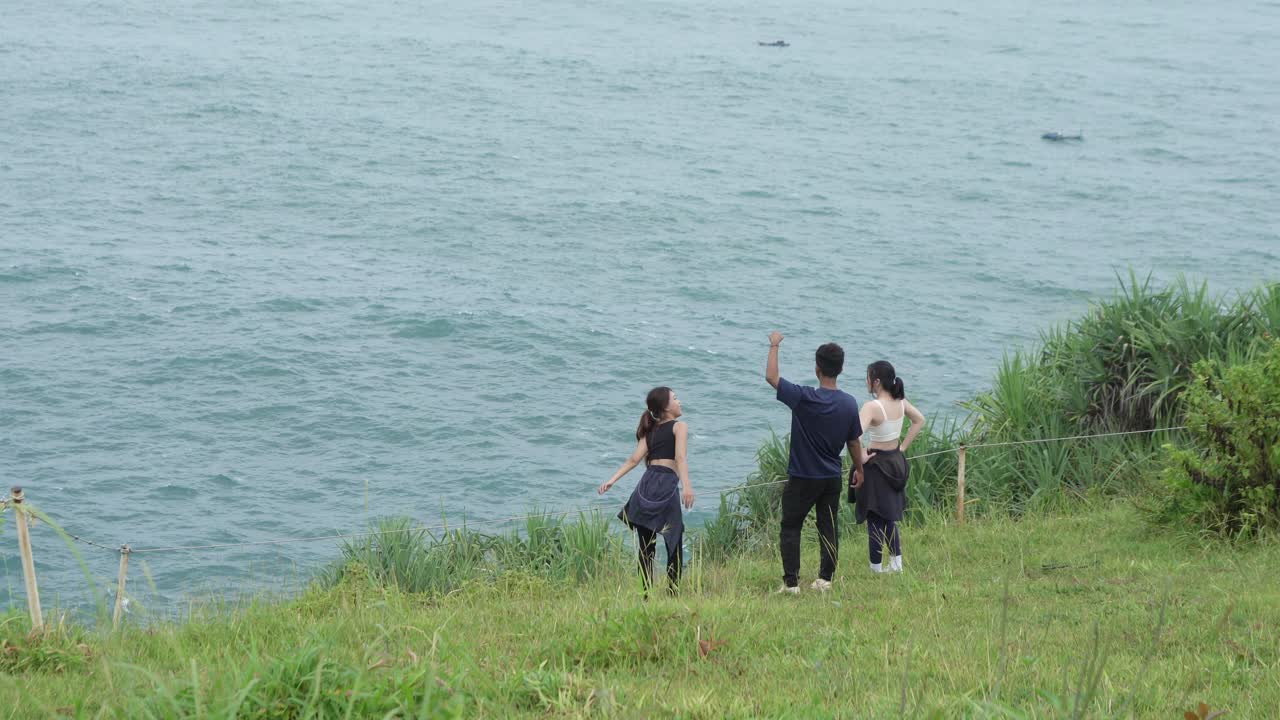 Friends enjoying the ocean view from a cliff