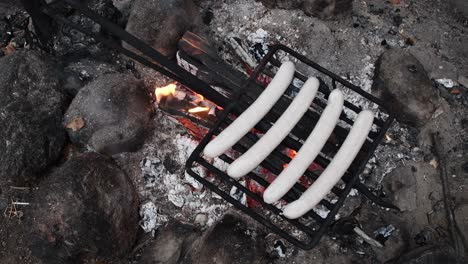 grilling sausage bratwursts on open camp fire