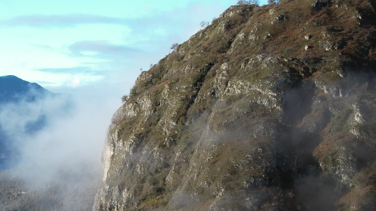 Dramatic aerial view of the Alps in Italy with clouds and rocky cliffs