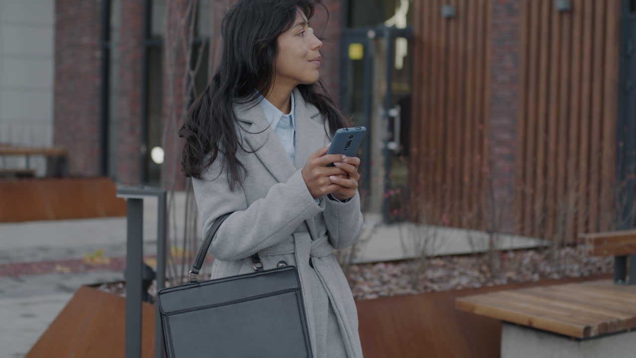 밖에서 스마트폰을 사용하는 사업가