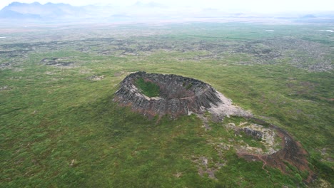 crater landscape volcano eldborg in iceland aerial, fertile soil, panoramic drone shot, flying scenic island, bright hazy day, sunlight blue sky