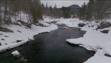 Malerische-Drohne-Aus-Der-Luft,-Schwenk-Vorwärts,-Stromaufwärts,-Kanadische-Wildnis,-Mitten-Im-Winter,-In-Der-Nähe-Des-Skigebiets-Stoneham-Im-Norden-Von-Quebec,-Gefroren-über-Dem-Sautaurski-Fluss