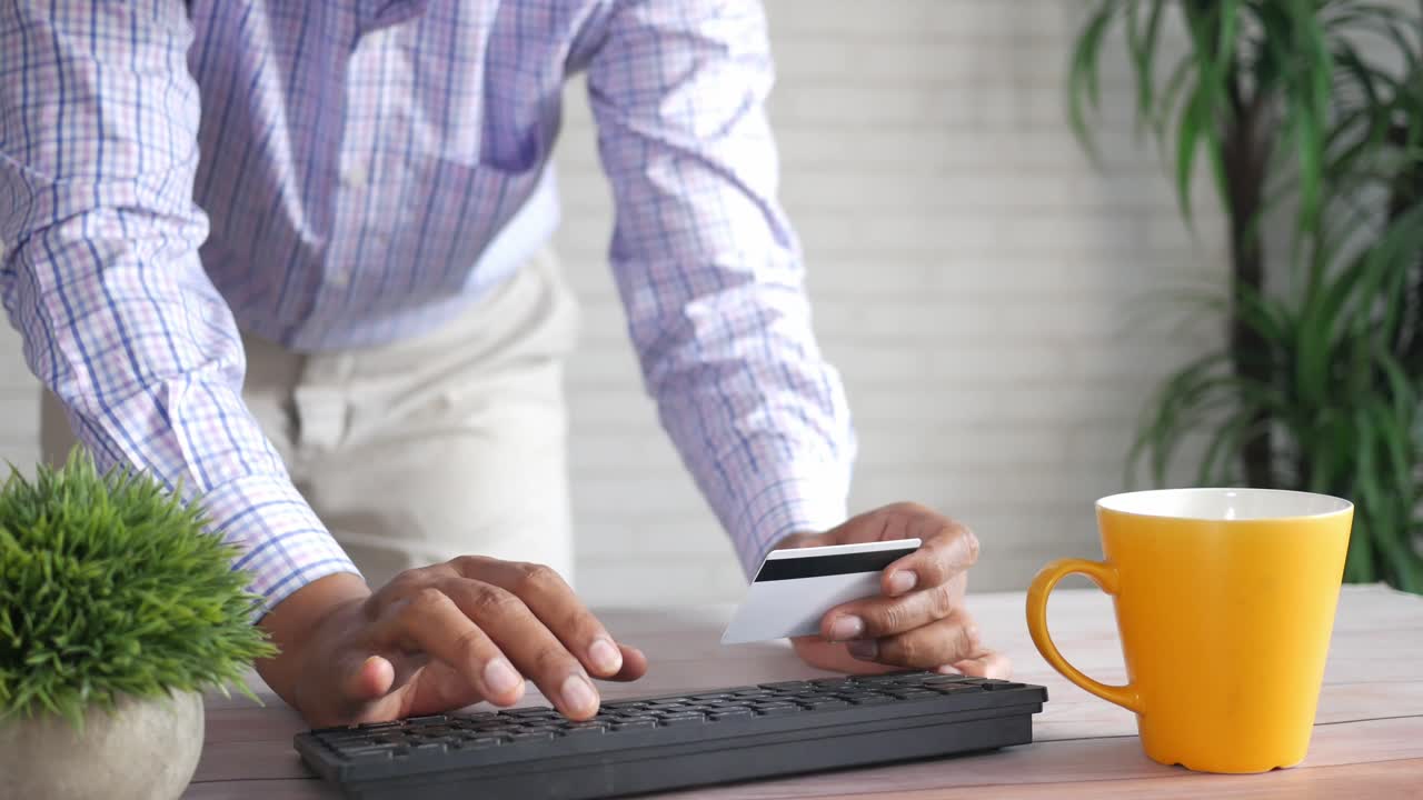 pessoa que paga online usando cartão de crédito num computador