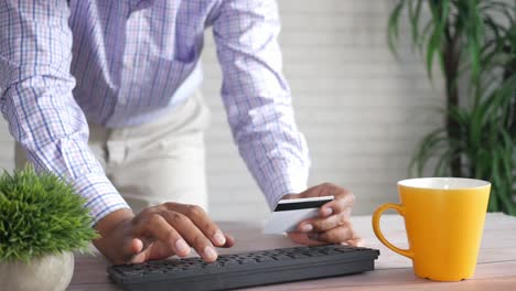 persona que paga en línea utilizando una tarjeta de crédito en una computadora