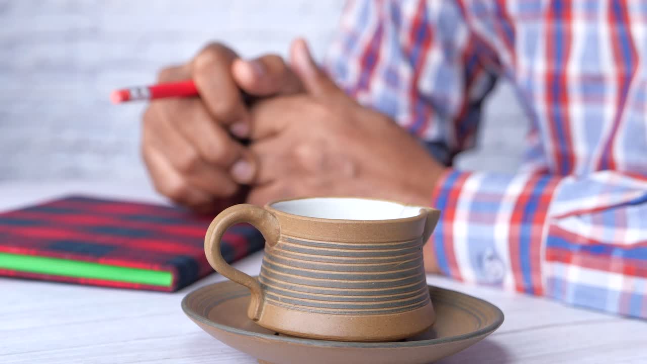 persona que escribe en el cuaderno en el escritorio