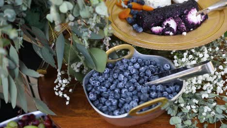 Elegante-Exhibición-De-Platos-De-Frutas-Con-Arándanos-Y-Decoración-Floral