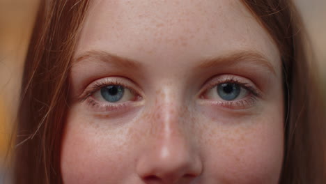 Close-up-macro-portrait-of-freckles-child-kid-face-smiling,-teen-blue-girl's-eyes-looking-at-camera