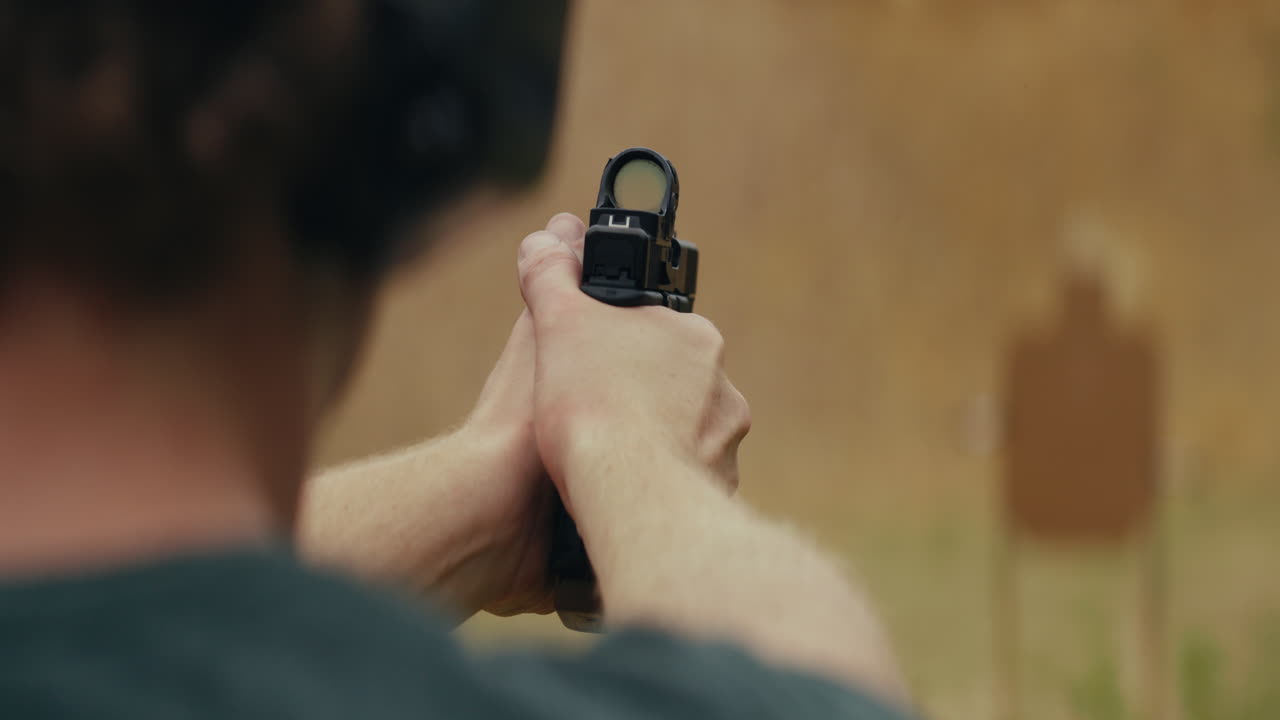 Person aiming a pistol at a target