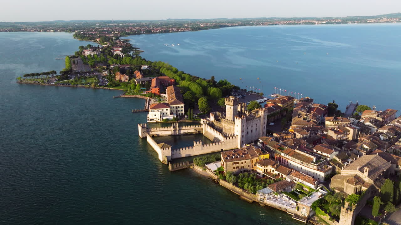 Aerial View Of Castello Scaligero At Sunrise On Lago di Garda In Sirmione, Italy. tilt-down shot