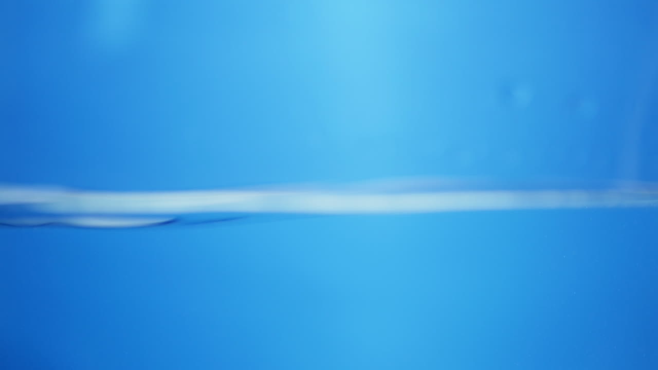 Water splashing against a surface with transparent bubbles floating, symbolizing freshness, cleanliness, and fluidity. Perfect for background overlays.