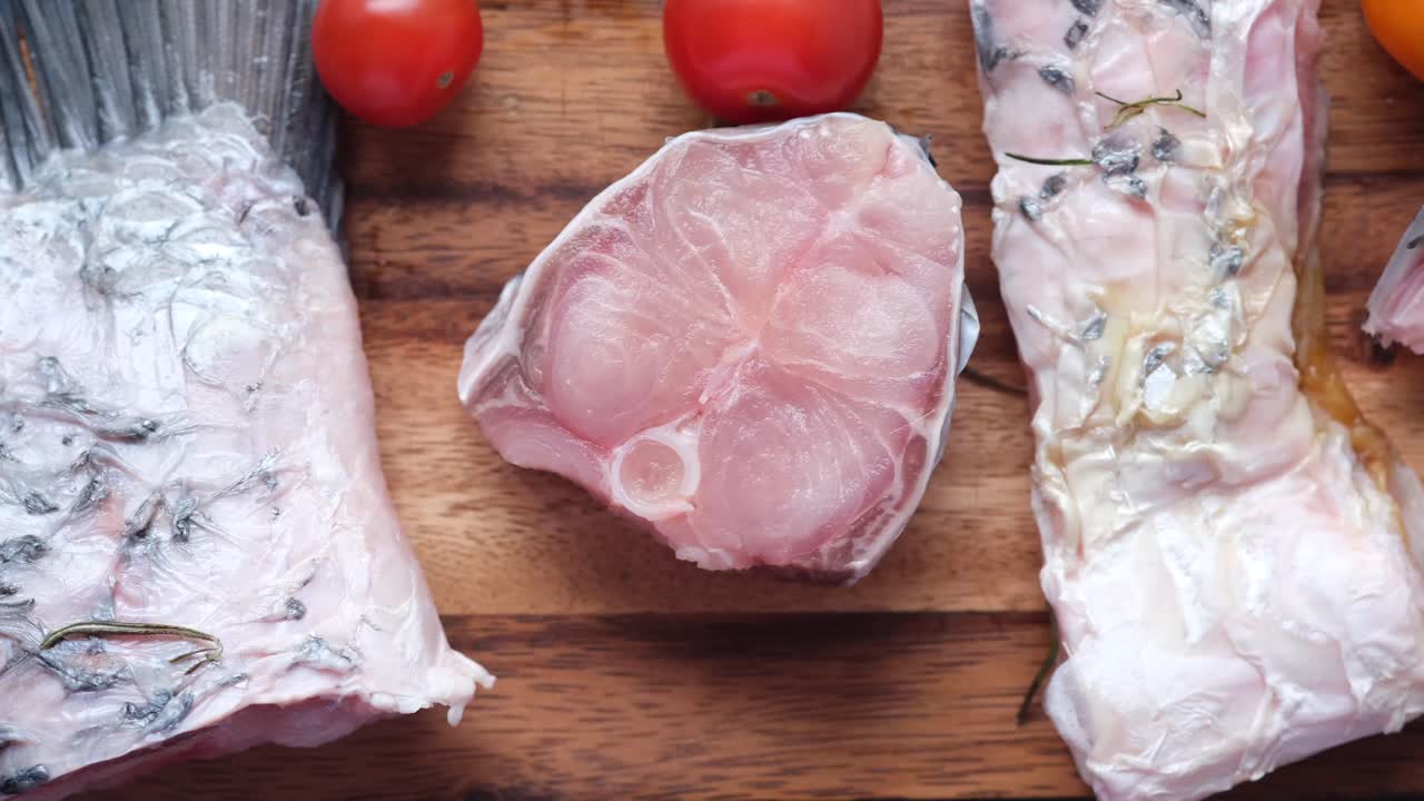 토마토와 함께 나무 절단판에 생선 필레 조각