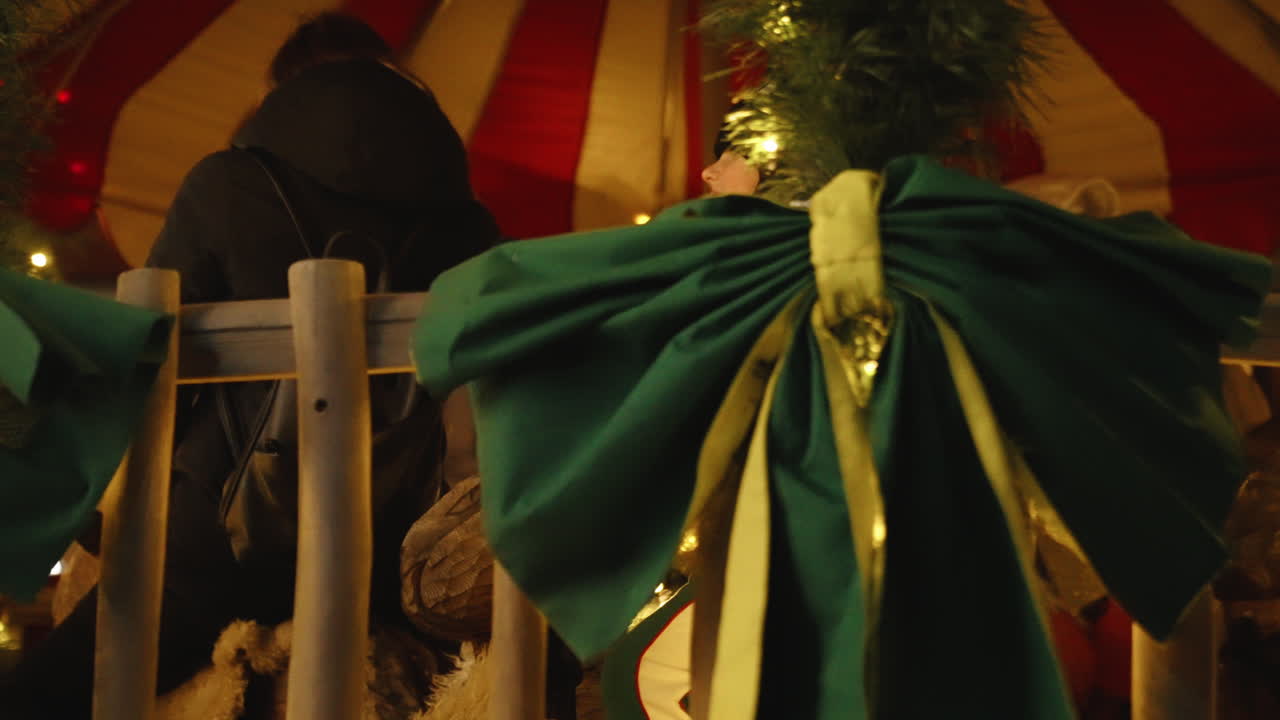 Christmas decorations on display at the Christmas market in Riga, Latvia, holiday spirit as woman rides on carousel with child