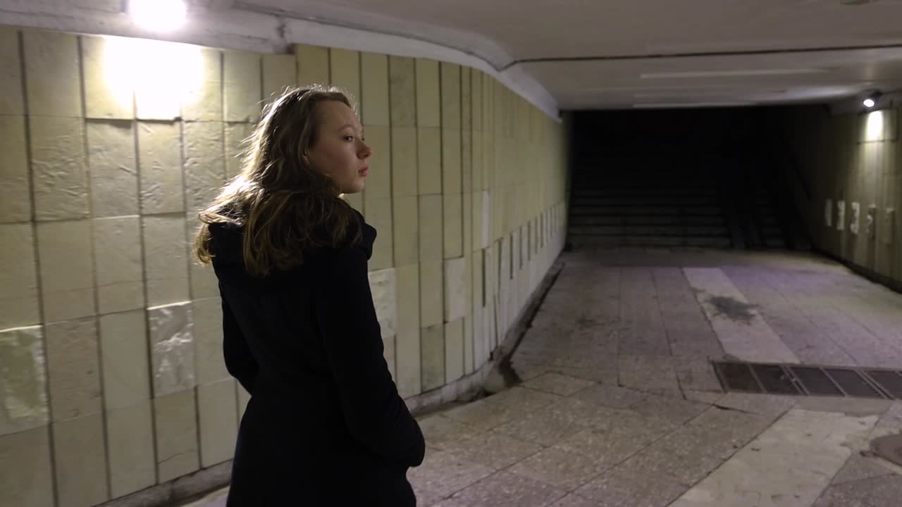 Girl walking out from the underground passage in the night