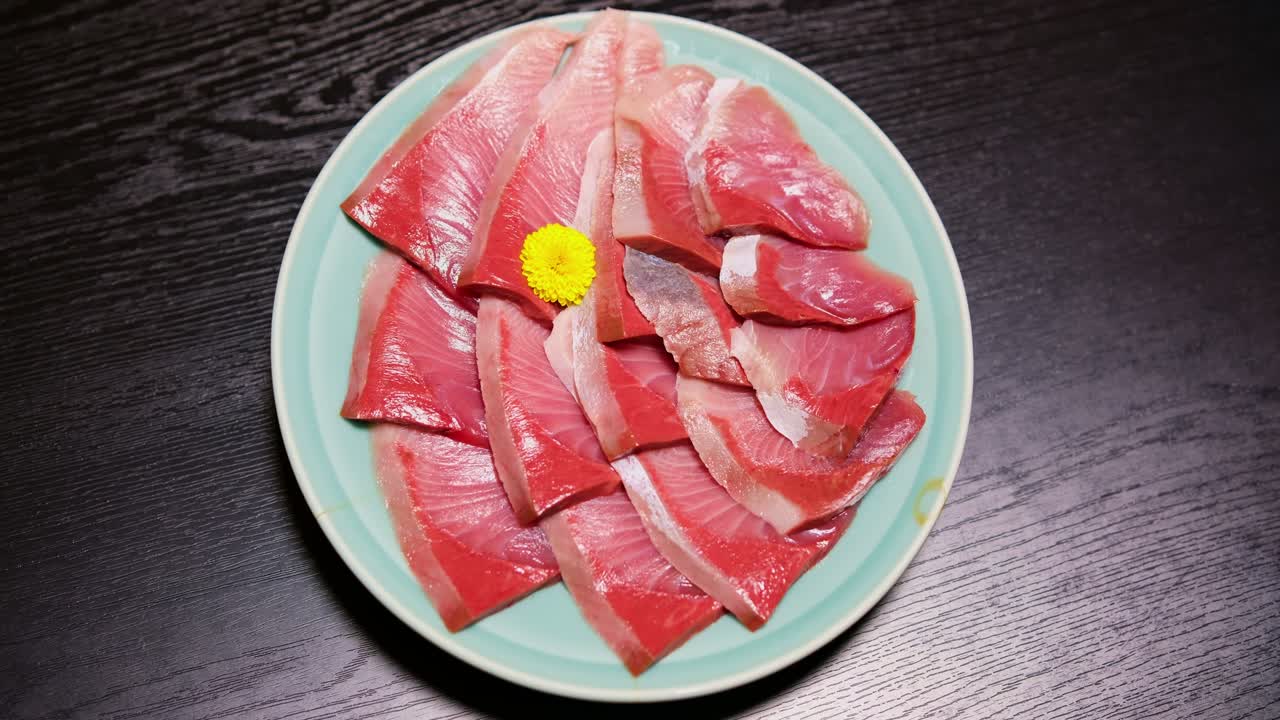 Buri Shabu Sashimi vibrante su piatto blu, primo piano ad alto contrasto di cibo giapponese