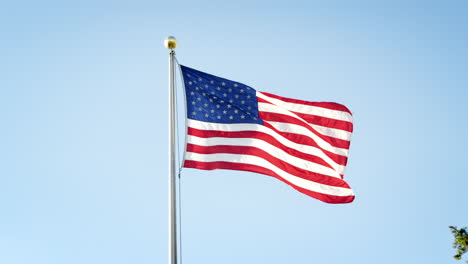 American-Flag-Flying-Against-Clear-Blue-Sky-In-Slow-Motion