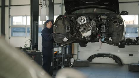 mechanic repairing car engine in auto workshop