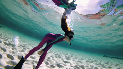young person snorkeling underwater in clear blue water
