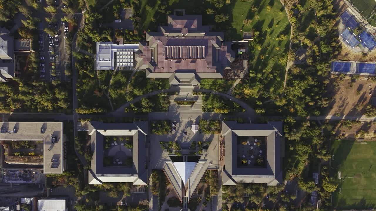 Descida vertical de drone em direção aos principais edifícios acadêmicos e jardins da Universidad de los Andes, San Carlos de Apoquindo, Las Condes, Chile, 4K